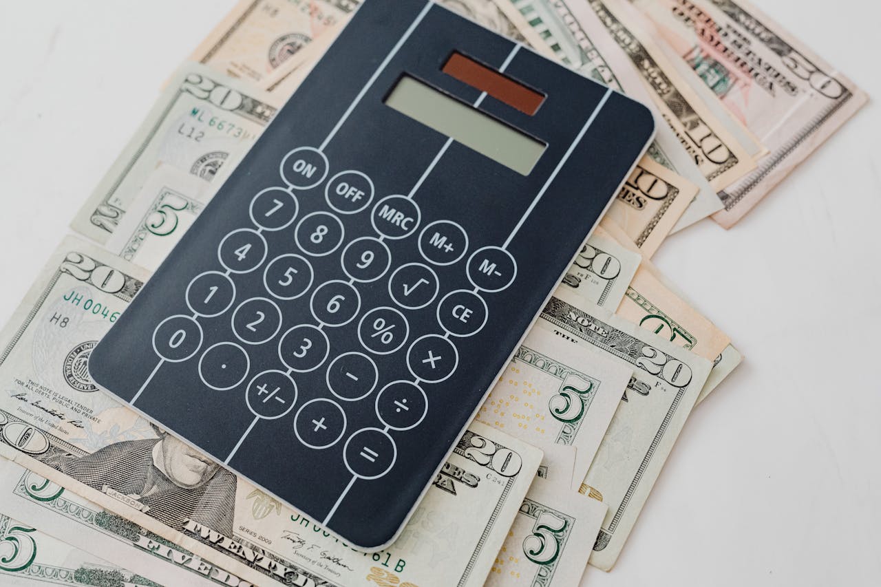 Close-up of a calculator atop US dollar bills, symbolizing financial planning and budgeting.